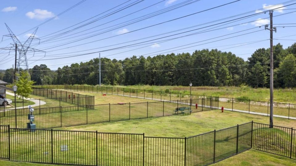 a fenced in area with power lines and trees at The Auberge of Tyler